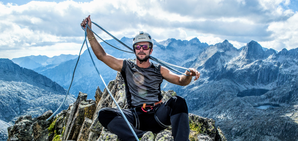 About-us-header2 Guia de muntanya preparant material d'escalada durant ruta de trekking als Pirineus