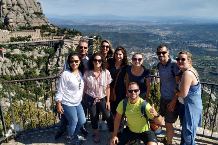 a group of people posing for a photo in front of a mountain