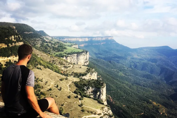 Guy sitting on the edge of the Rupit Moutains in Catalonia