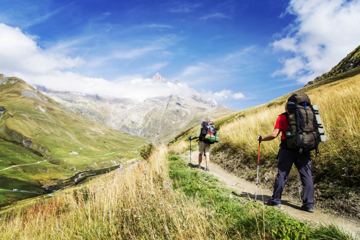 a group of people walking on the side of a mountain